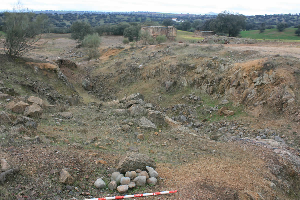 Tecnologías de explotación  minera
En Las Minillas-1 se han descubierto muy distintas  fases de explotación minera, que han dejado sus diferentes huellas grabadas en  un mismo paisaje. La acumulación de mazas de piedra con acanaladura transversal  de enmangue corresponde a la tecnología minera prehistórica, con la que se  abrió la trinchera que sigue la misma dirección del filón mineral de cobre. Al  fondo se levantan las bocas cuadradas de mampuesto de los dos pozos mineros del  siglo XIX.   