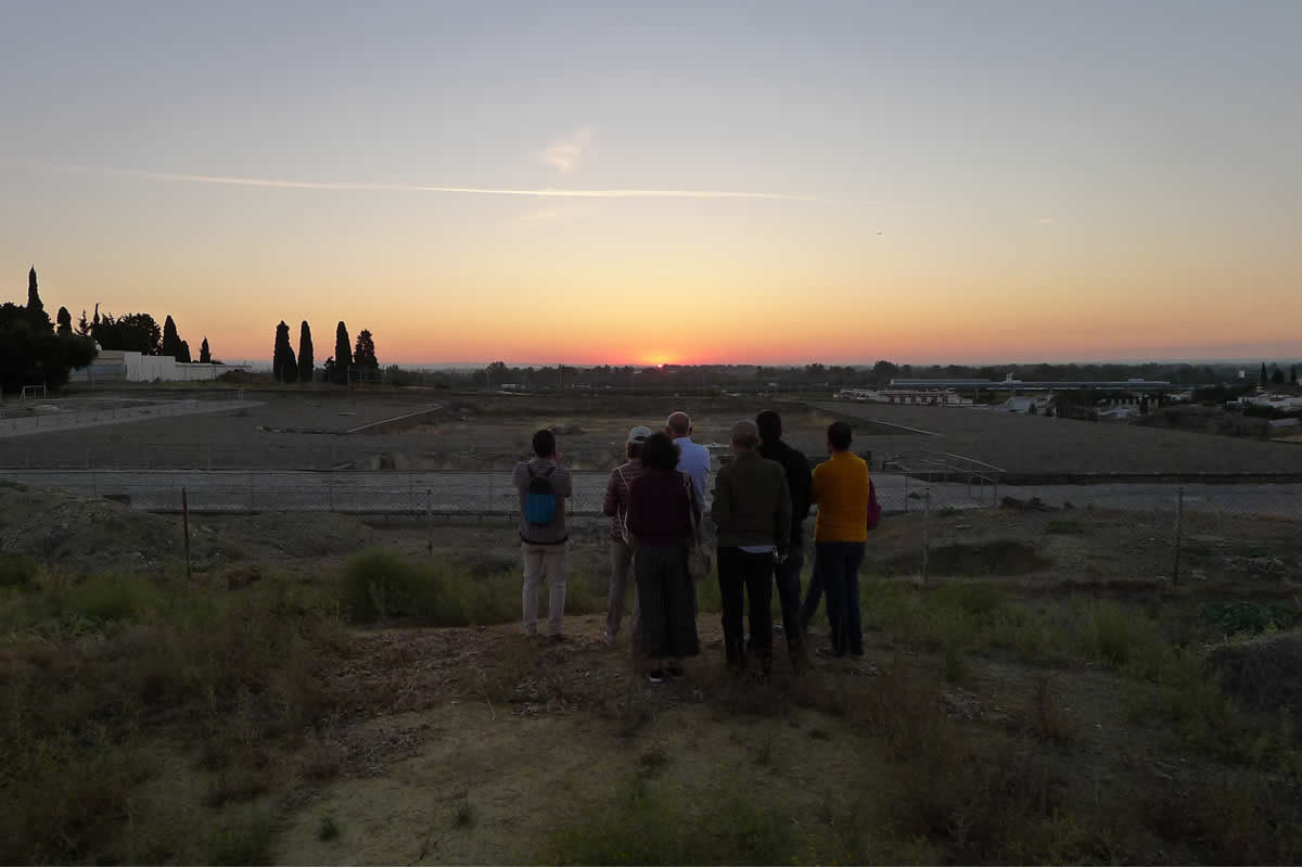 Eres como el Sol, como Baal en el cielo
  Los miembros del proyecto han preparado el encuentro  con la divinidad solar desde varios meses antes. Planificaron los permisos para  poder entrar antes del amanecer al recinto del Conjunto Arqueológico de  Itálica. Y aguardaron pacientemente a que el astro rey apareciera por el  horizonte oriental, que lo hizo precedido de su cohorte urania: Venus, Lucero  de la Mañana y Reina de los Cielos, y la divina Aurora de rosáceos dedos.
  Pero la espera dio los frutos deseados. Se pudo  comprobar que el Traianeum italicense busca el orto solar del solsticio de junio,  siguiendo una tradición oriental que celebraba la muerte y resurrección de Baal  y de otras divinidades equivalentes en esa fecha del año.
  El título de la fotografía es parte de un texto del  II milenio a.C. hallado en Egipto, que reza:
  &quot;Al rey, mi señor, mi Sol, mi dios: correo de  Abi-Milku, tu servidor. Me postro a los pies del rey, mi señor, siete veces y  siete veces. No soy más que polvo bajo los pies y las sandalias del rey, mi  señor. ¡Oh rey, mi señor!, tú eres como el Sol, como Baal en el cielo&quot; (El  Amarna 149. Tiro).